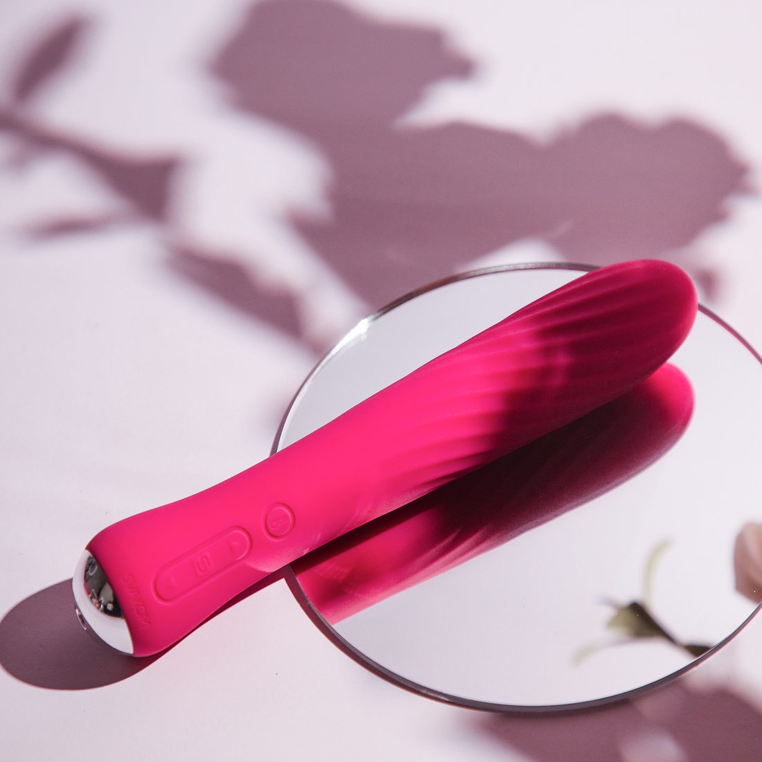 Różowy wibrator Svakom Anya leżący na okrągłym lusterku